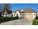 Beautiful white brick home with a manicured lawn and driveway leading to a beige garage at 1655 Rosebud Ln, Greenwood, IN 46143