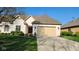 Beautiful white brick home with a manicured lawn and driveway leading to a beige garage at 1655 Rosebud Ln, Greenwood, IN 46143