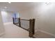 Hallway with carpeted floors, a wooden railing, and natural lighting from nearby rooms at 1655 Rosebud Ln, Greenwood, IN 46143