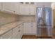 Kitchen area featuring stainless steel refrigerator, granite countertop and ample cabinetry at 1655 Rosebud Ln, Greenwood, IN 46143