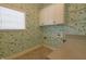 Bright laundry room with playful wallpaper, upper cabinets and countertop space at 1655 Rosebud Ln, Greenwood, IN 46143