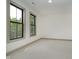 This is an empty bedroom with two windows, light carpeting, and white walls at 1818 Central Ave, Indianapolis, IN 46202