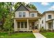 Inviting two-story home with a covered porch, complemented by lush landscaping at 1818 Central Ave, Indianapolis, IN 46202