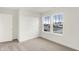 Bright bedroom features neutral carpet, closet, and a large double window offering neighborhood views at 2004 Foothill Dr, Greenfield, IN 46140
