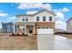 Inviting two-story home featuring a brick and vinyl facade, attached two-car garage, and a freshly poured concrete driveway at 2004 Foothill Dr, Greenfield, IN 46140
