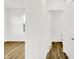 Hallway featuring laminate flooring, white walls, and doorways leading to a bathroom at 2004 Foothill Dr, Greenfield, IN 46140