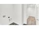 Bright laundry room features hookups, gray flooring, and white walls leading to a carpeted hallway at 2004 Foothill Dr, Greenfield, IN 46140
