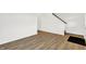 Open living area with light laminate flooring, white walls, and a view of the staircase, creating a bright and airy space at 2004 Foothill Dr, Greenfield, IN 46140