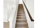 Carpeted staircase with white walls and dark wood railing leads to the next level at 2004 Foothill Dr, Greenfield, IN 46140
