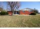 Backyard showcasing the brick exterior, sunroom addition, and expansive lawn at 2566 S Ritter Ave, Indianapolis, IN 46203