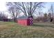 Exterior view of red barn-style storage shed with white trim, complementing the landscape at 2566 S Ritter Ave, Indianapolis, IN 46203