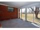 Sunroom with carpet flooring, brick accent wall, and sliding glass doors to the backyard at 2566 S Ritter Ave, Indianapolis, IN 46203