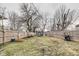 Spacious backyard with a wooden fence, grass, trees, and a trampoline at 2962 Station St, Indianapolis, IN 46218