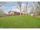 A large backyard with lush green lawn, mature trees, and a wooden fence, offering privacy and space at 3549 Woodale Rd, Indianapolis, IN 46234