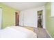 Another view of the bright bedroom with neutral walls, carpet, and access to the hallway at 3549 Woodale Rd, Indianapolis, IN 46234