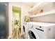 Convenient laundry room with modern washer and dryer, shelving, and access to additional rooms at 3549 Woodale Rd, Indianapolis, IN 46234