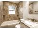 Updated bathroom featuring tiled walls, shower-tub combo, and modern vanity at 3944 Strathmore Dr, Indianapolis, IN 46235