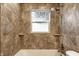 Close up of the shower featuring tiled walls and built-in shelves at 3944 Strathmore Dr, Indianapolis, IN 46235