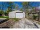 View of the detached garage with a white door and gravel driveway at 3944 Strathmore Dr, Indianapolis, IN 46235