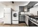 Bright kitchen with stainless steel stove and sink, adjacent washer, dryer, and refrigerator at 3944 Strathmore Dr, Indianapolis, IN 46235