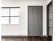 Bright living room with a large window, gray door and wood-look flooring at 3944 Strathmore Dr, Indianapolis, IN 46235