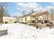 This backyard features a wood deck with pergola, yellow siding, and a snow covered yard at 401 W Westfield Blvd, Indianapolis, IN 46208