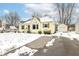 Charming yellow home featuring green shutters, a detached garage, and snowy surroundings at 401 W Westfield Blvd, Indianapolis, IN 46208