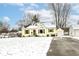Quaint yellow house featuring green shutters, white garage and snow-covered front yard at 401 W Westfield Blvd, Indianapolis, IN 46208