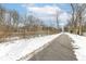 This path is paved and next to a creek with snow covered banks and a tree line at 401 W Westfield Blvd, Indianapolis, IN 46208