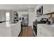 Modern kitchen with stainless steel appliances, white cabinets, quartz countertops, and a stylish faucet at 4040 Jacoby Pl, Indianapolis, IN 46268