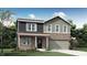 Charming two-story home featuring a brick facade, a covered front porch and an attached two-car garage at 4046 Jacoby Pl, Indianapolis, IN 46268