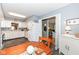 Eat-in kitchen with white cabinets, view of the dining area and office, and laminate floor at 4501 N Wheeling Ave # 10A-101, Muncie, IN 47304