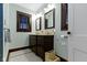 Bathroom with double vanity, dark wood trim, and stylish lighting fixtures at 4805 N Park Ave, Indianapolis, IN 46205
