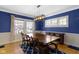 Bright dining room with a rustic wooden table, modern chandelier, and ample natural light at 4805 N Park Ave, Indianapolis, IN 46205