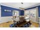 Elegant dining room with a spacious table, large windows, and stylish blue accent wall at 4805 N Park Ave, Indianapolis, IN 46205