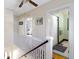 Upstairs hallway featuring white railing, hardwood floors, and doorways into bedrooms and bathroom at 4805 N Park Ave, Indianapolis, IN 46205