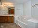 Well-lit bathroom with double sinks, a soaking tub, and tile surround at 4912 Eagle Talon Ct, Indianapolis, IN 46254
