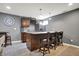 Basement bar area with seating, stylish cabinetry, and granite countertops at 5147 Nicodemus Dr, Plainfield, IN 46168