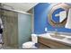 Bathroom features stylish blue accent wall, vanity, decorative mirror, toilet and tile shower at 5147 Nicodemus Dr, Plainfield, IN 46168