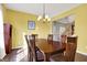 Dining room featuring wood floors, a chandelier, and a view into the entryway, painted in bright yellow at 5147 Nicodemus Dr, Plainfield, IN 46168