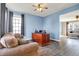 Home office featuring a spacious desk, comfortable seating area, ceiling fan, and views into the living spaces at 5147 Nicodemus Dr, Plainfield, IN 46168
