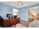 Comfortable home office with a large desk, couch, ceiling fan, and wood-look floors for a productive workspace at 5147 Nicodemus Dr, Plainfield, IN 46168