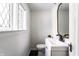 Powder room featuring sleek vanity, updated fixtures, and diamond pattern windows at 5715 N Delaware St, Indianapolis, IN 46220