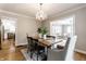 Bright dining room featuring wood floors, modern chandelier, and a view to the living room at 5715 N Delaware St, Indianapolis, IN 46220