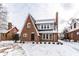 Beautiful brick home with snow-covered yard, mature trees, and architectural details at 5715 N Delaware St, Indianapolis, IN 46220