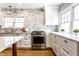 Bright kitchen with marble backsplash, stainless steel range, and white cabinetry at 5715 N Delaware St, Indianapolis, IN 46220