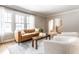 Bright living room featuring large windows, leather sofa, and open archway to stairs at 5715 N Delaware St, Indianapolis, IN 46220