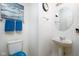 A compact bathroom features a round mirror, a pedestal sink, and tiled floors at 6236 White Rabbit Pl, Indianapolis, IN 46235