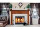 Cozy fireplace with decorative mantle, tile surround, and glass door, with windows on either side at 6236 White Rabbit Pl, Indianapolis, IN 46235