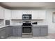 Bright kitchen with stainless steel appliances, two-tone cabinets, mosaic backsplash and light flooring at 6236 White Rabbit Pl, Indianapolis, IN 46235